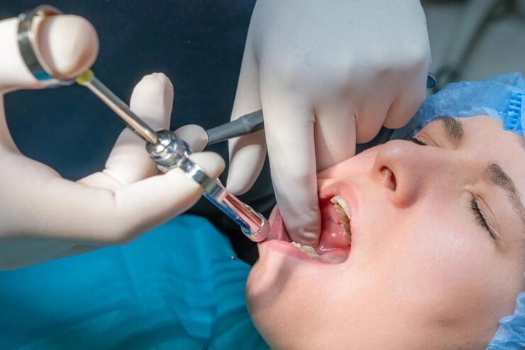 dentist administers local anesthetic injection into patient gums woman wearing blue surgical cap 177415 7308