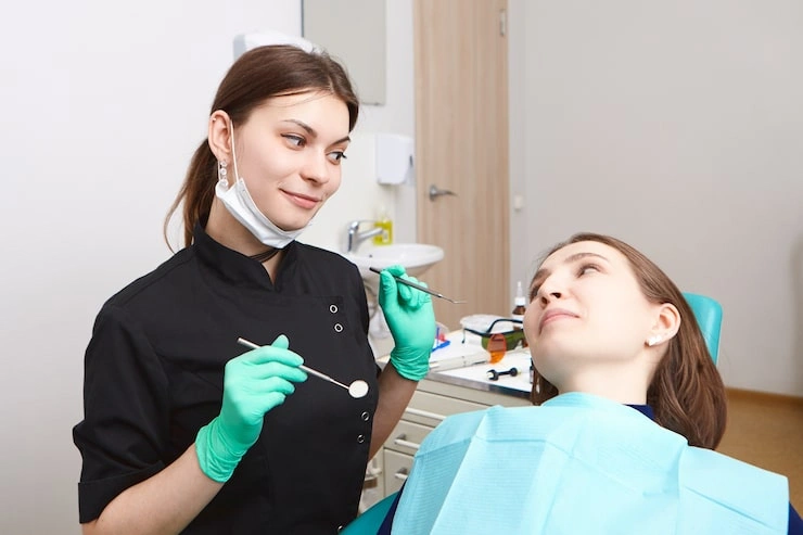 experienced attractive young brunette woman dentist holding dental tools while checking teeth female patient cavities 343059 399 1