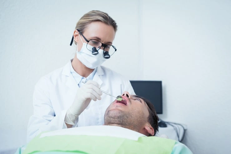 female dentist examining mans teeth 13339 69516
