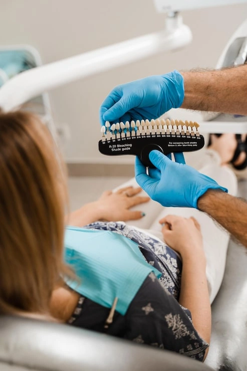 woman looking veneers implants teeth color matching samples doctor hands dentistry dentist demonstrate teeth color shades guide tooth whitening woman patient dental clinic 255847 6940